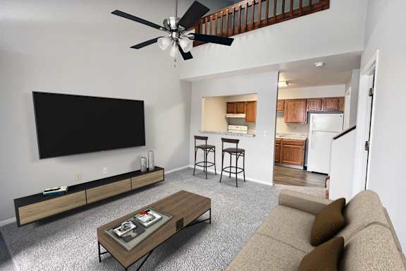 A living room with a couch, a coffee table, and a television.