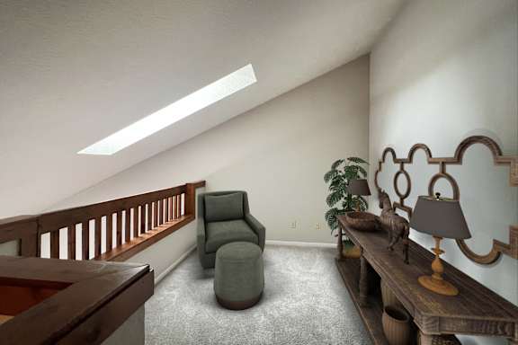 A living room with a grey armchair and a wooden table with a lamp on it.