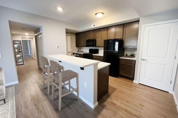 an open kitchen and dining area with a white counter top