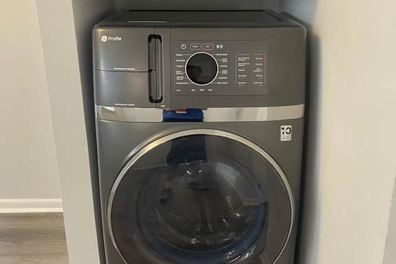 A front-loading washing machine with a transparent door.