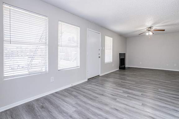 A room with a ceiling fan and a door.