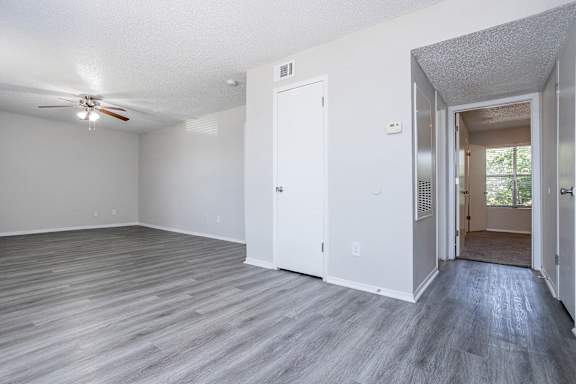 A room with a ceiling fan and a door.