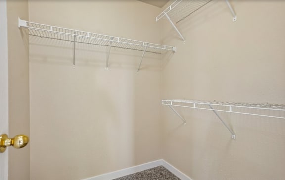 A room with a white door and two white shelves.