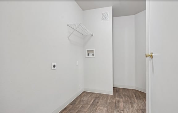 A white room with a light switch and a door.