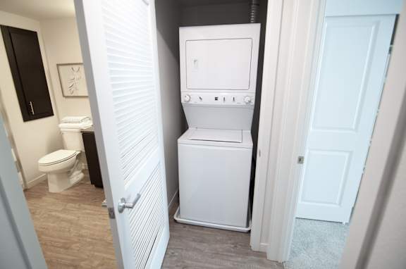 A white washing machine in a small bathroom.