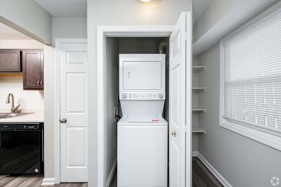 A white dishwasher is in a kitchen next to a white door.
