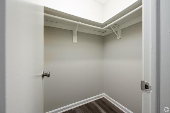 A white door with a silver handle is open to a room with a skylight.