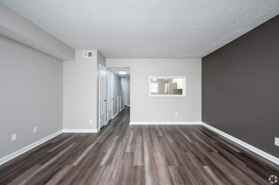 A long hallway with wood floors and white walls.