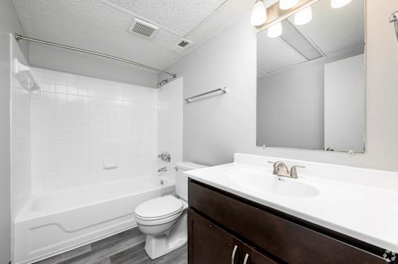 A white bathroom with a toilet, sink, and bathtub.
