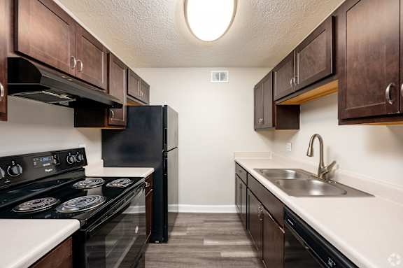 A kitchen with black appliances and wooden cabinets.
