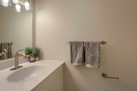 A bathroom with a white sink and towel rack.