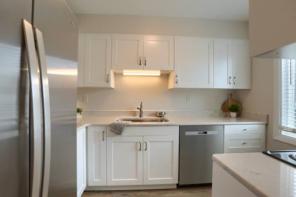 two bedroom townhouse kitchen with white cabinets and a stainless steel refrigerator
