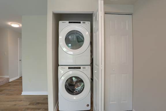A white washing machine and dryer in a small laundry room.