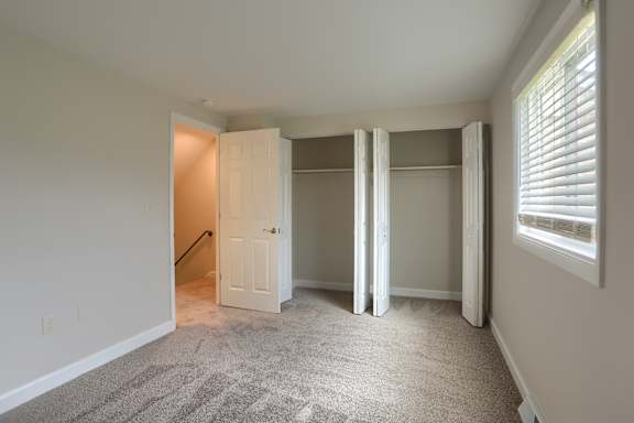 A room with a carpeted floor and a white door.