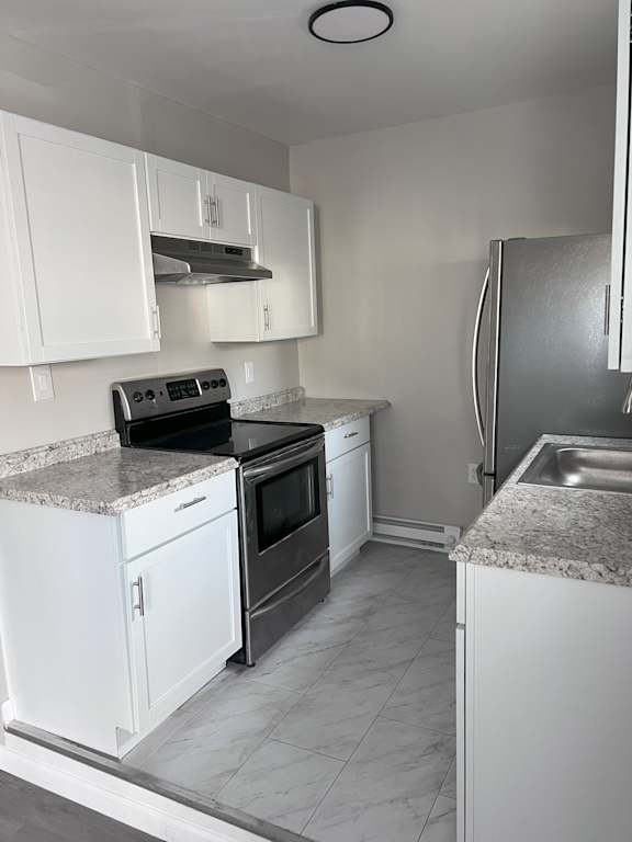 A kitchen with white cabinets and a granite countertop.