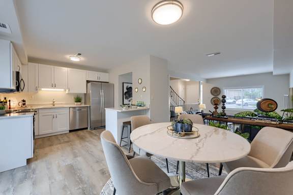 A modern kitchen with a dining table and chairs.