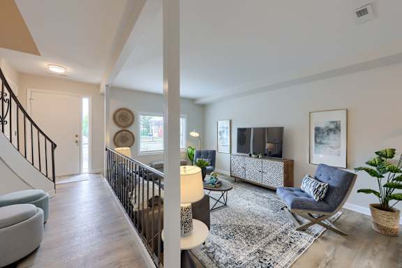 A living room with a grey couch and a wooden floor.