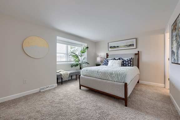 A bedroom with a large bed and a window.