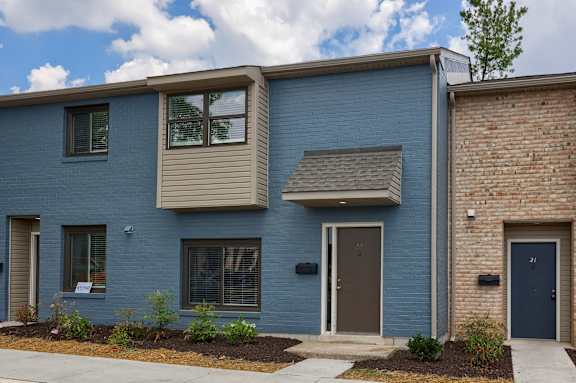 A blue house with a brown door and windows.