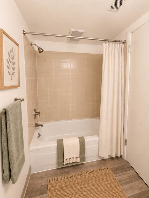 A bathroom with a white tub and a green towel hanging on the wall.