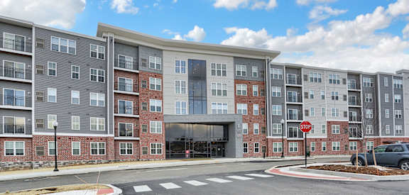 an apartment building on a street corner with a stop sign
