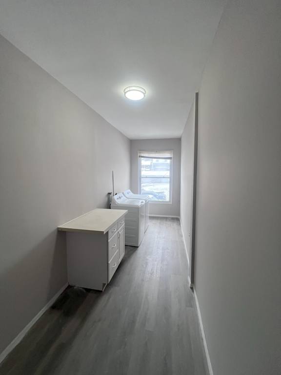 A long hallway with a desk and a window.