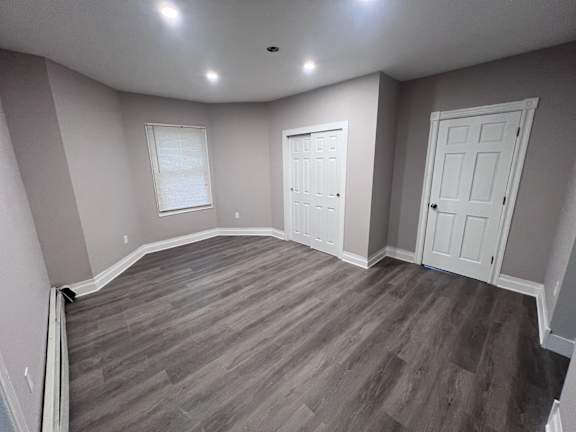 A room with a curved wall and wood flooring.