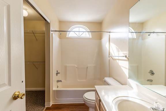 A white bathroom with a toilet, sink, and bathtub.