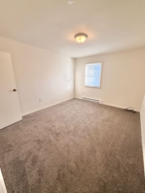 A room with a carpeted floor and a window.