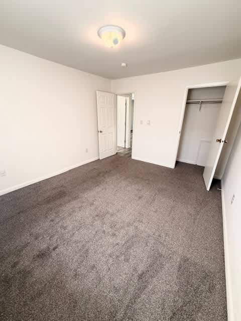 A room with carpeted floor and white walls.
