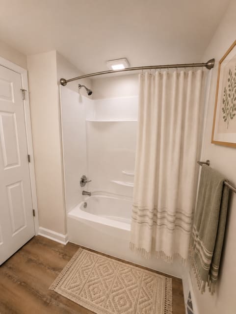 A white bathroom with a white tub and a white door.