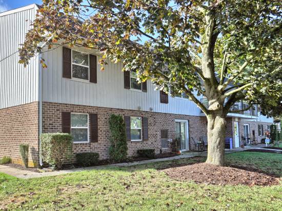 a brick house with a tree in front of it