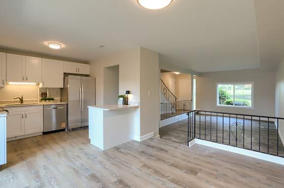 A kitchen with white cabinets and a refrigerator.