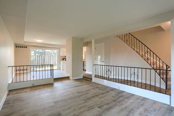 A spacious room with a staircase and a balcony.