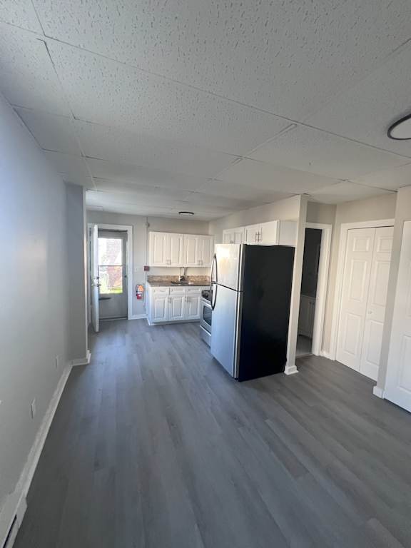 A kitchen with a black fridge and white cabinets.