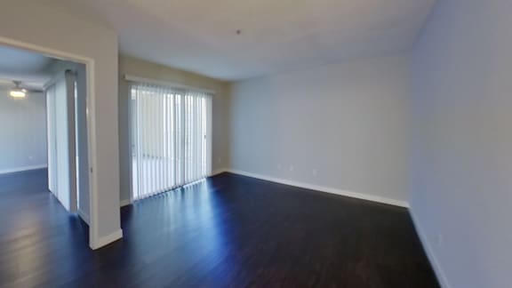 an empty living room with wood floors and white walls