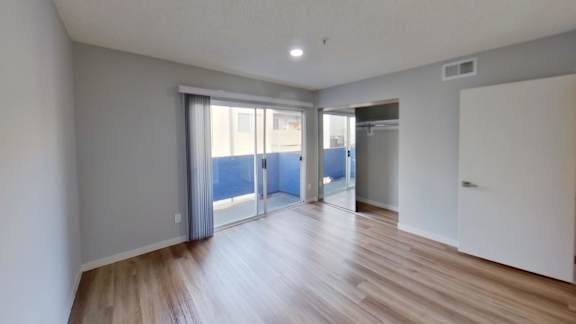 A room with wooden floors and sliding glass doors.