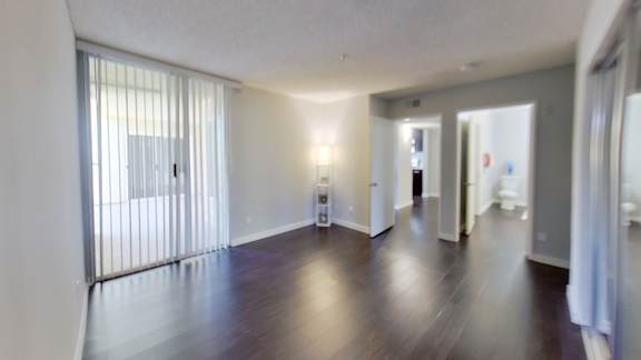 an empty living room and hallway with wood floors and white walls