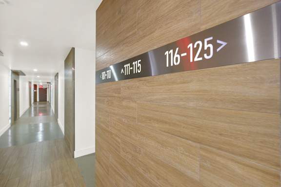 A long hallway with a wall that has a sign that says 116-125.