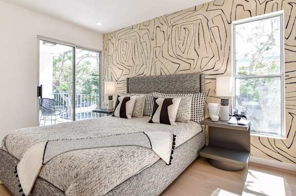 a bedroom with a bed and a wall with a mural on it at 8535 Colgate-Fully Furnished Apartments, Los Angeles, CA, 90048