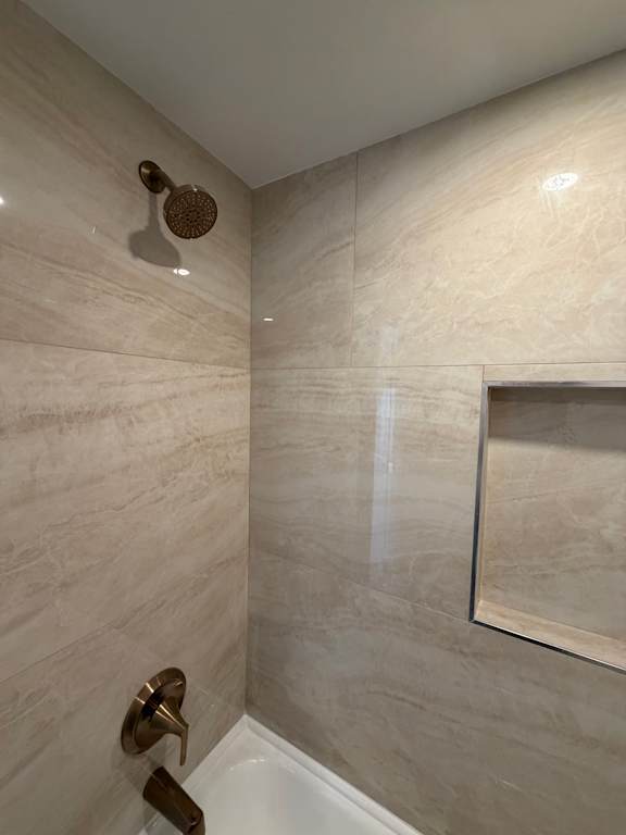 A bathroom with a toilet and a shower.
