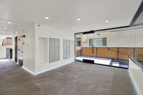 A spacious room with a long hallway and a balcony on the right side.