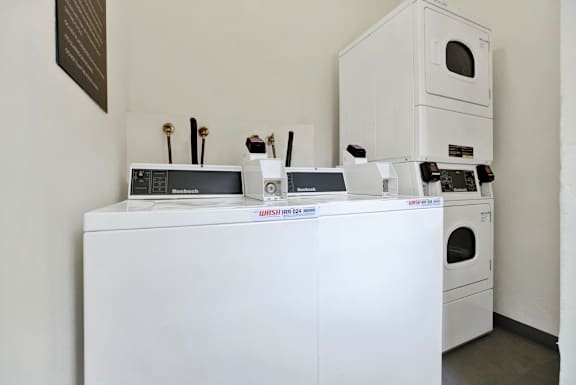 A white dishwasher and oven are on display in a room.