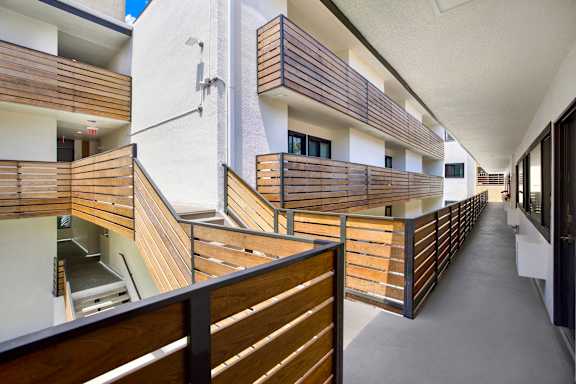 A long hallway with wooden railings and white walls.