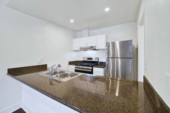 A kitchen with granite countertops and stainless steel appliances.