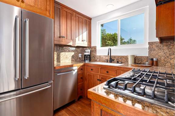 a kitchen with stainless steel appliances and wooden cabinets at 8535 Colgate-Fully Furnished Apartments, California