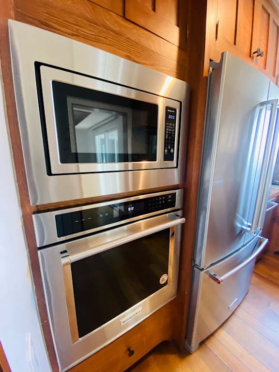 a kitchen with a stainless steel microwave oven and a refrigerator at 8535 Colgate-Fully Furnished Apartments, Los Angeles, CA