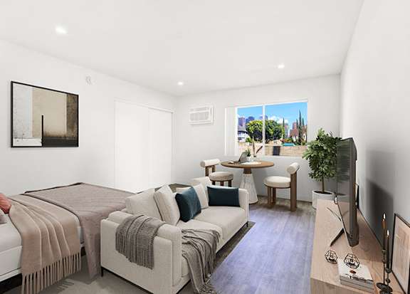 A living room with a couch, a chair, a television, and a window at Bonnie Brae Apartments, Apartments, Los Angeles, CA