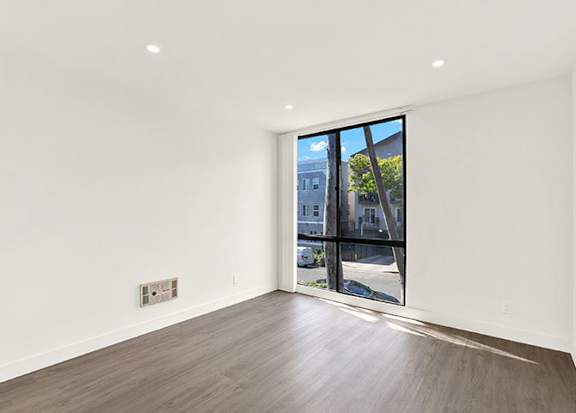 A room with a large window and wooden flooring at Bonnie Brae Apartments, Los Angeles, California