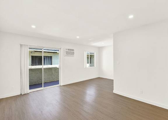 A room with a wooden floor and a doorway leading to a balcony at Bonnie Brae Apartments, Los Angeles, CA, 90006